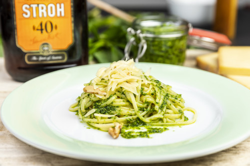 Pasta mit Bärlauch-Pesto mit STROH, serviert mit Walnüssen und Parmesan