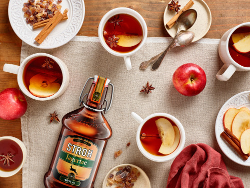 STROH Jagertee, zubereitet mit heißem Wasser und dekoriert mit Zimt, Sternanis und Äpfeln
